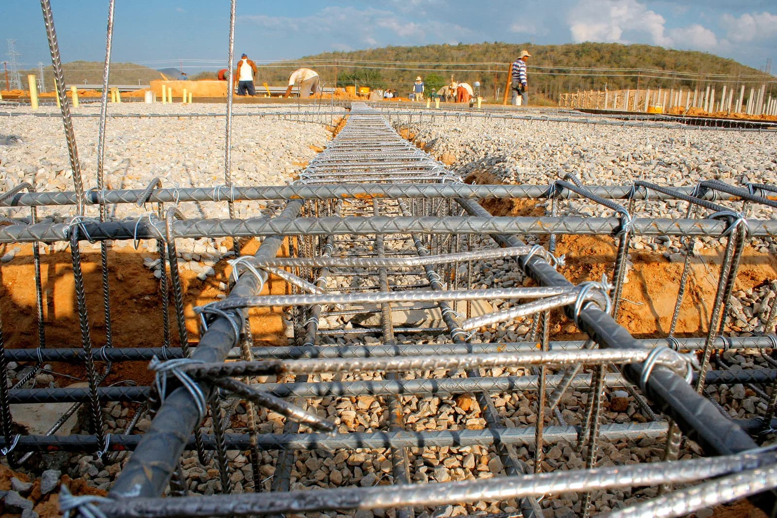 Illustration : armatures d’une semelle de fondation posées dans leur tranchée, sur un lit de gravier