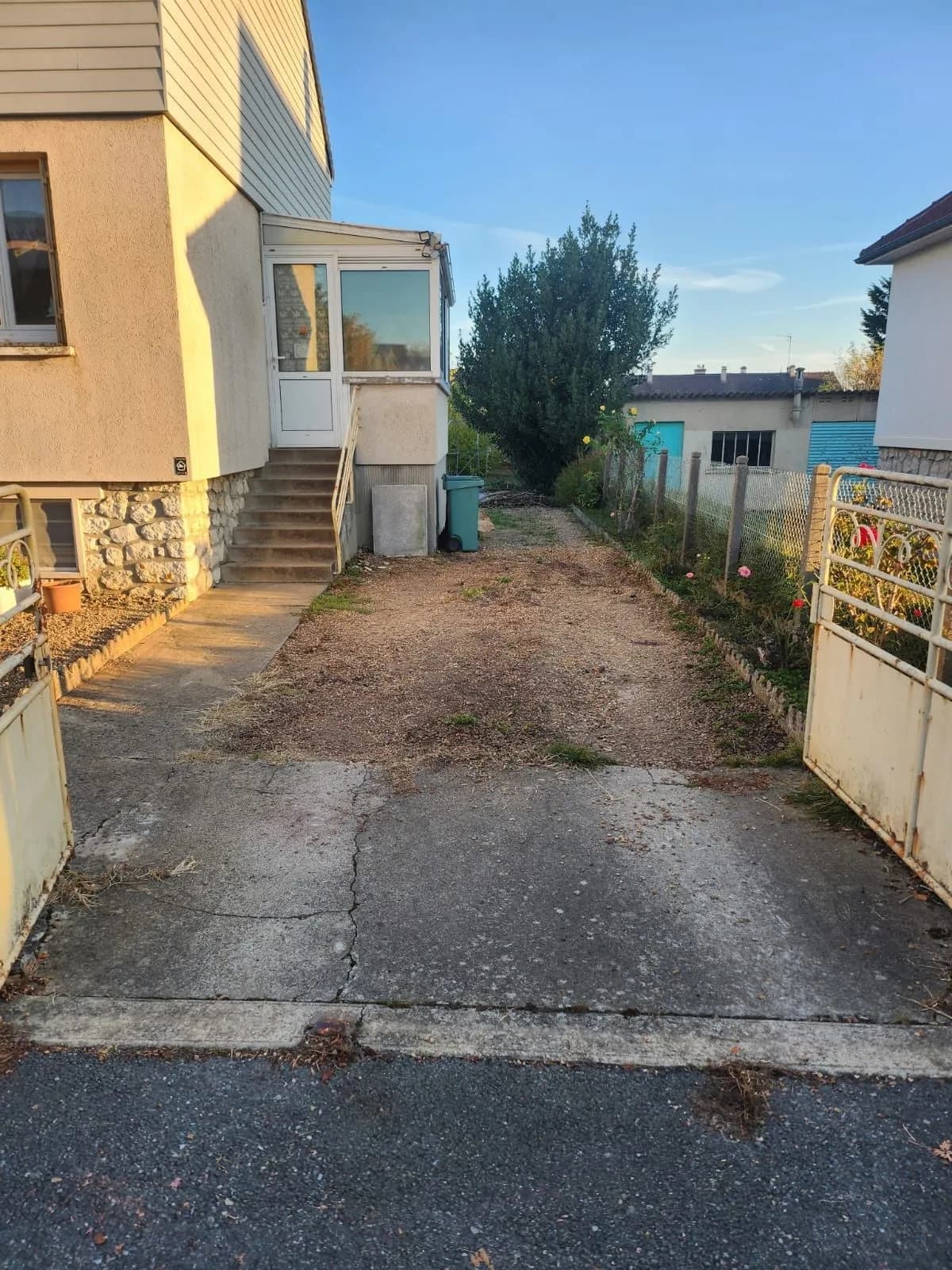 Allée de maison en terre et gravier usé, entrée en béton fissuré, avant le décaissement, chantier de SJ Rénovation, partenaire de Bouthors Couverture