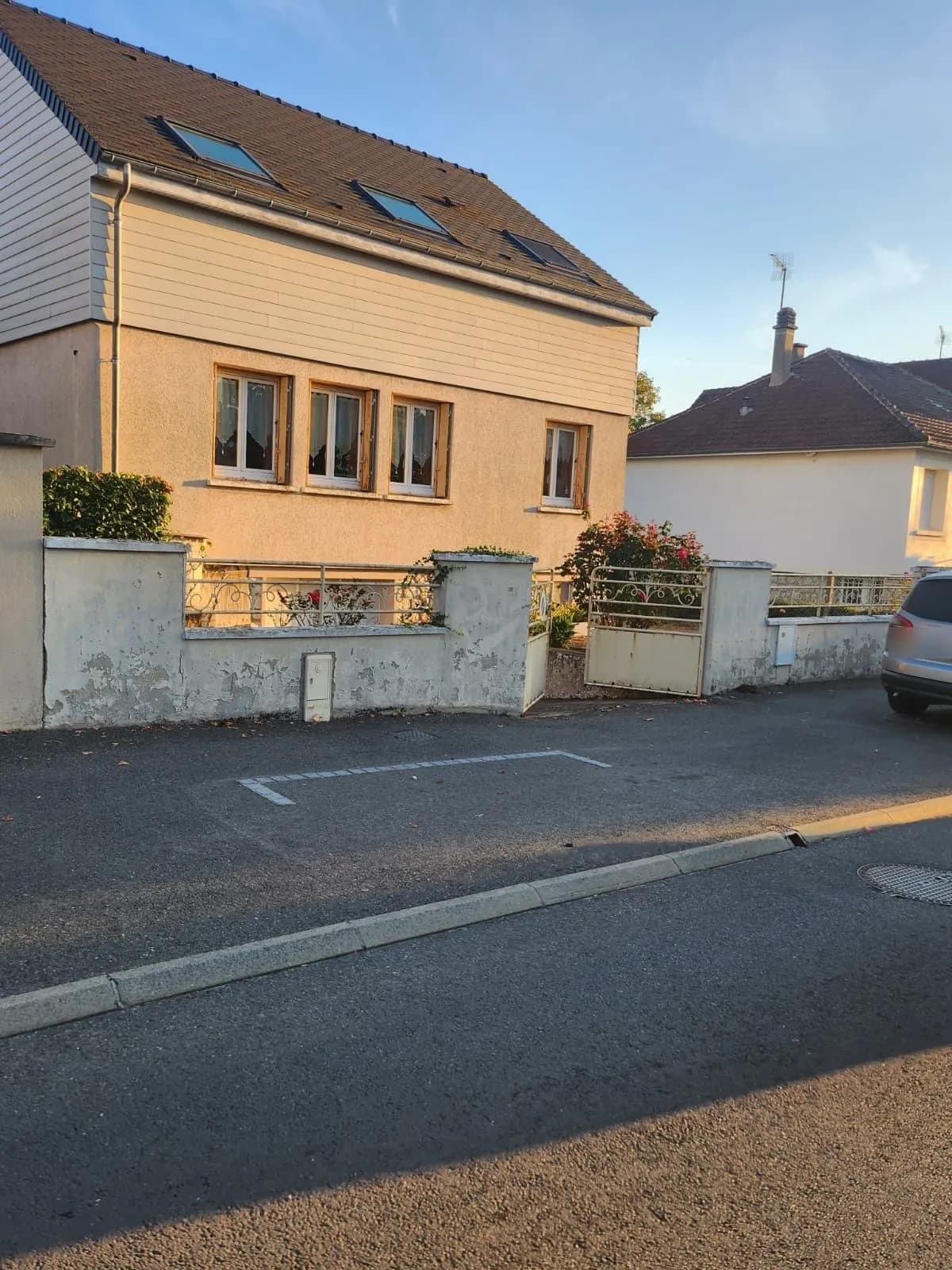 Le même mur de clôture vu depuis la rue, enduit écaillé, portail et grille anciens, chantier de SJ Rénovation, partenaire de Bouthors Couverture
