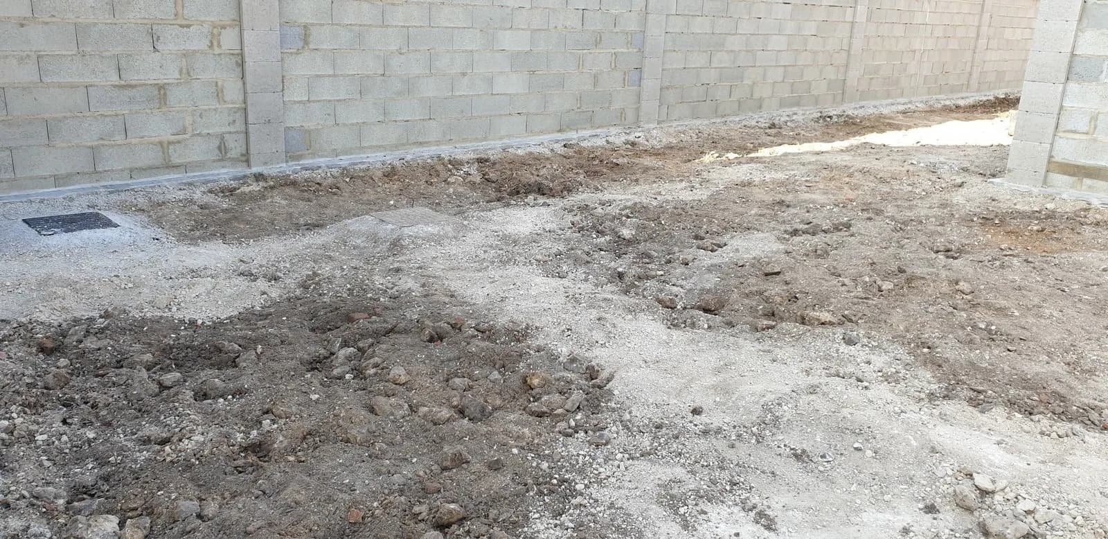 Cour décapée par Bouthors Couverture au pied d’un mur de clôture, avant la mise en forme