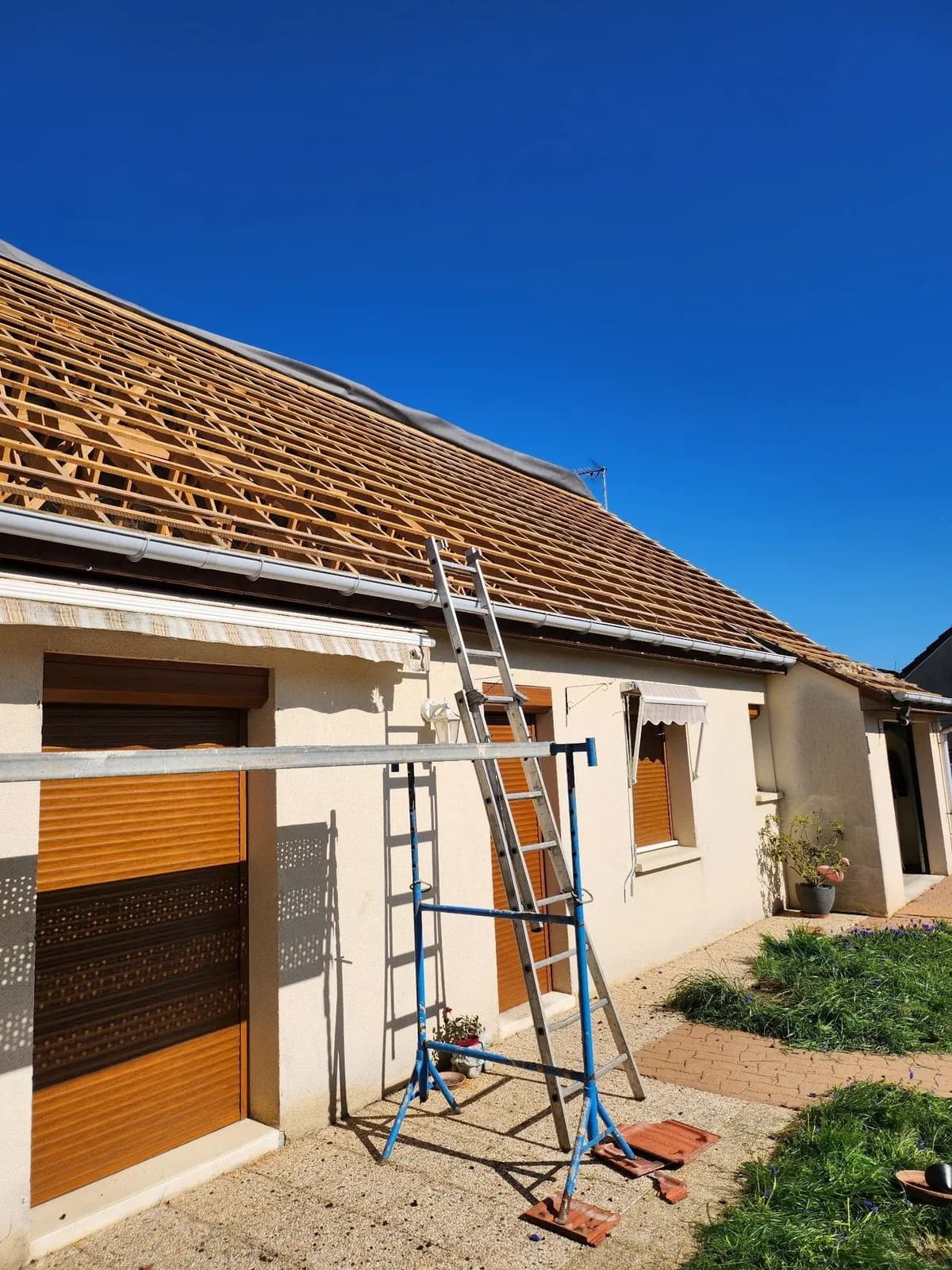 Versant de pavillon déshabillé jusqu’à la charpente, échafaudage et échelle de Bouthors Couverture en pied de façade